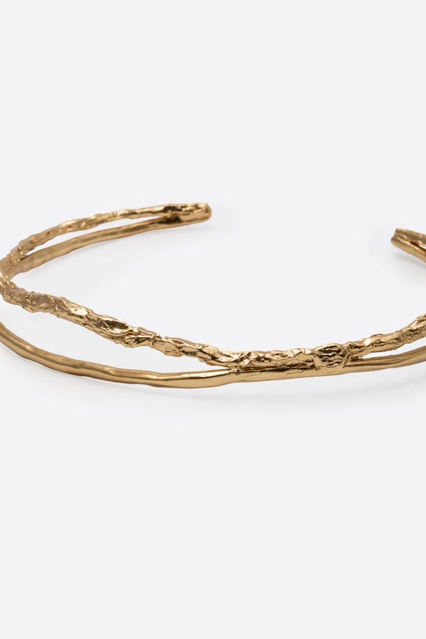 Close-up of sculptural gold choker necklace with textured finish