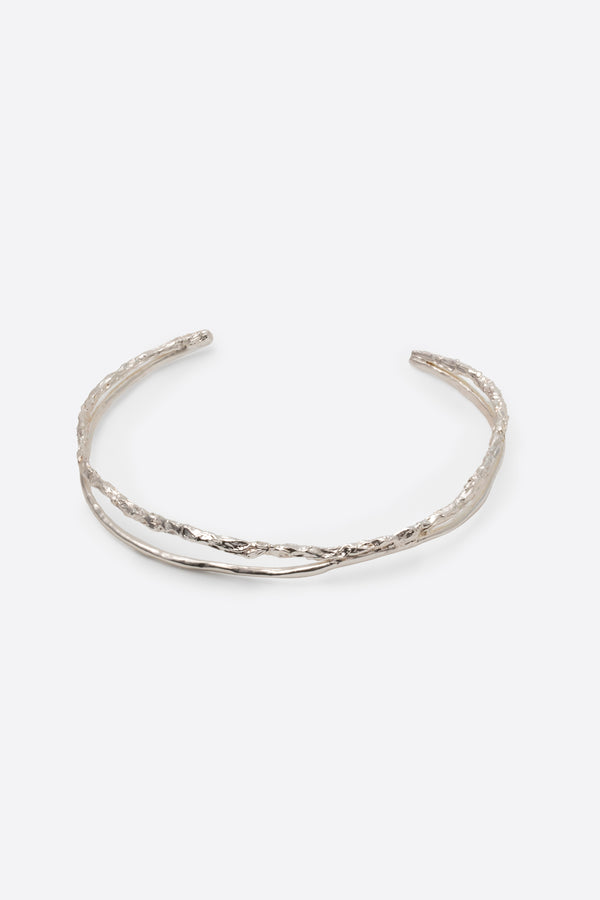 Sculptural silver choker necklace with organic texture on white background