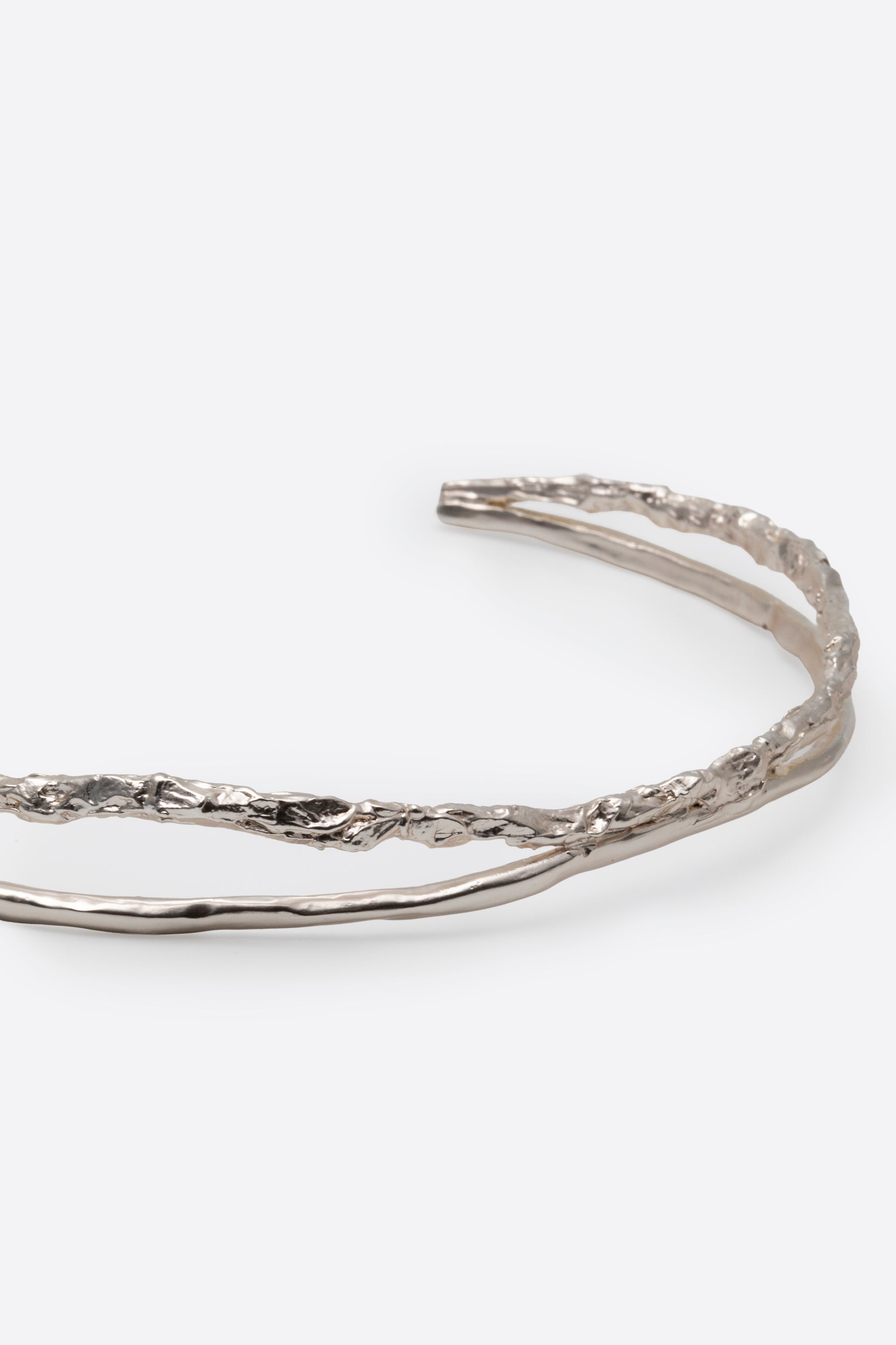 Close-up of sculptural silver choker necklace with textured finish