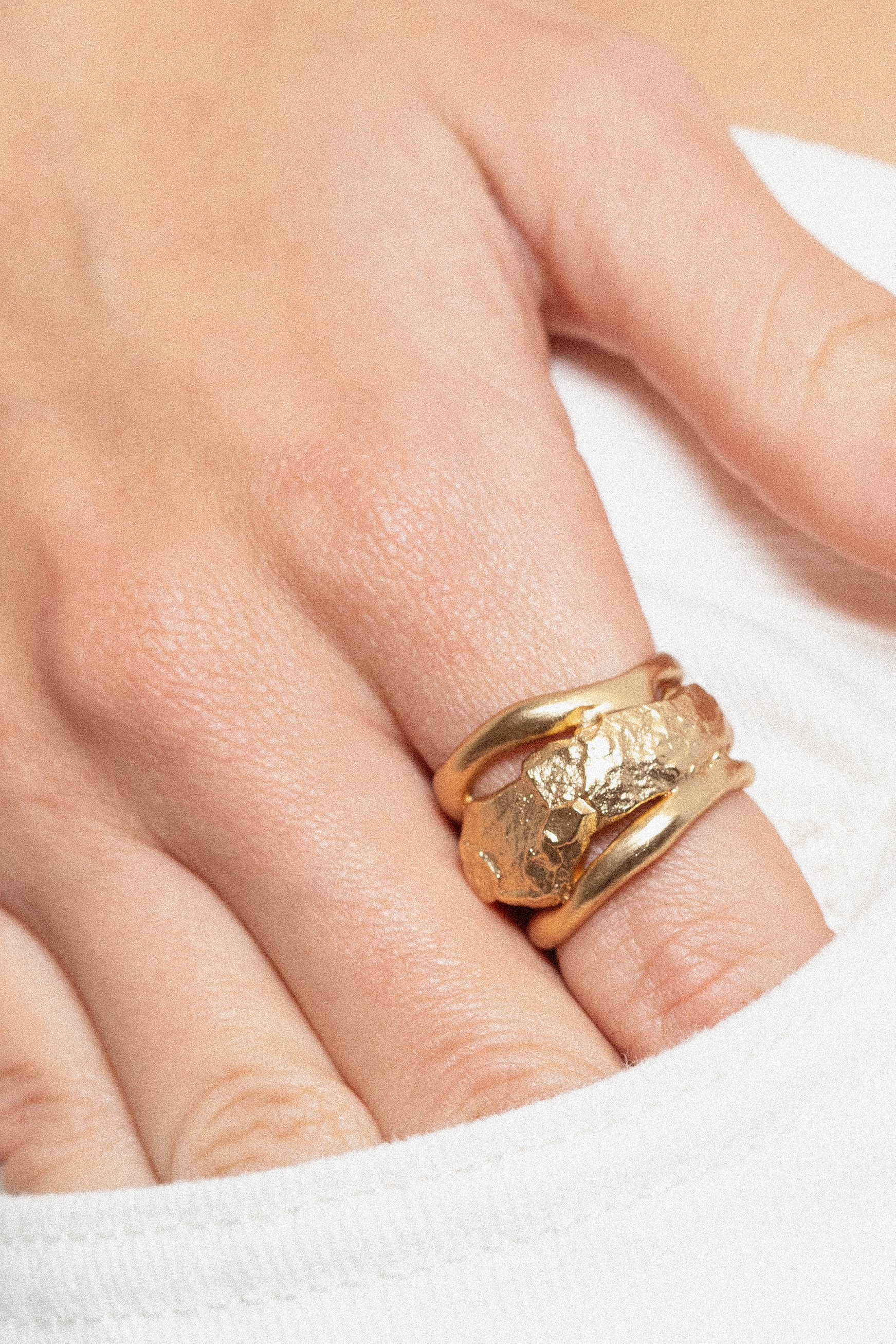 Model styling sculptural gold statement ring with contemporary jewelry look