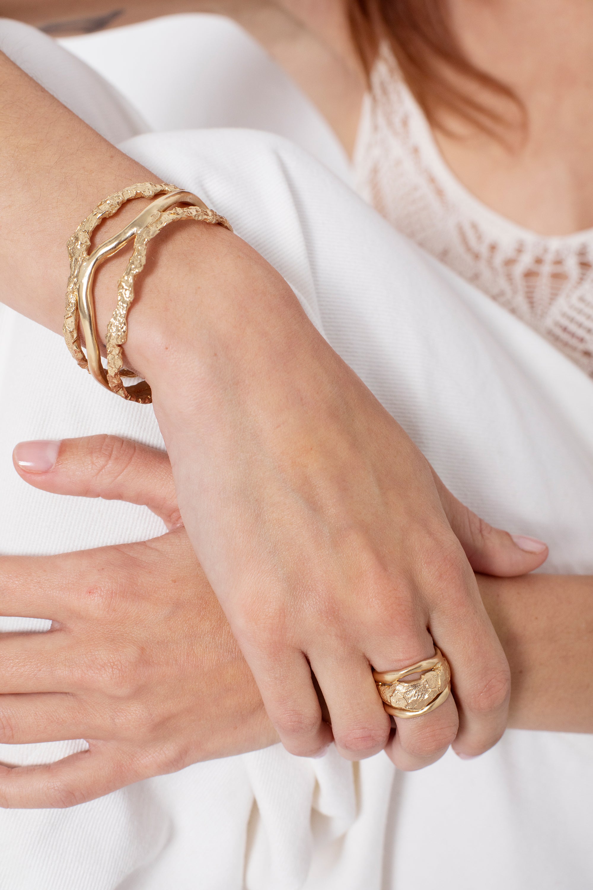 Woman wearing sculptural gold statement ring with organic texture