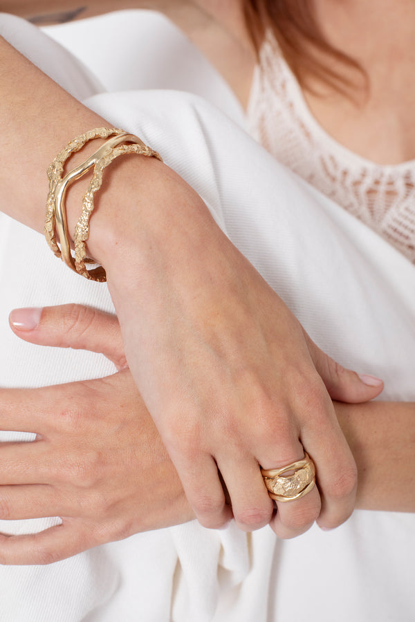 Woman wearing sculptural gold statement ring with organic texture