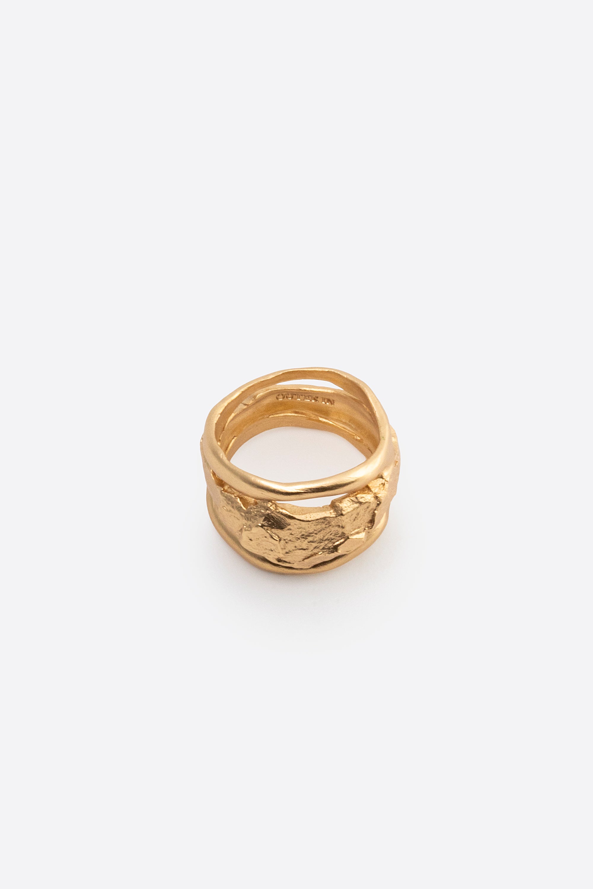 Sculptural gold statement ring with organic texture on white background