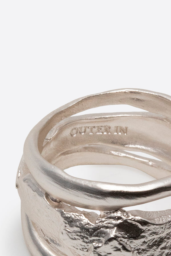 Close-up of sculptural silver statement ring with layered organic texture