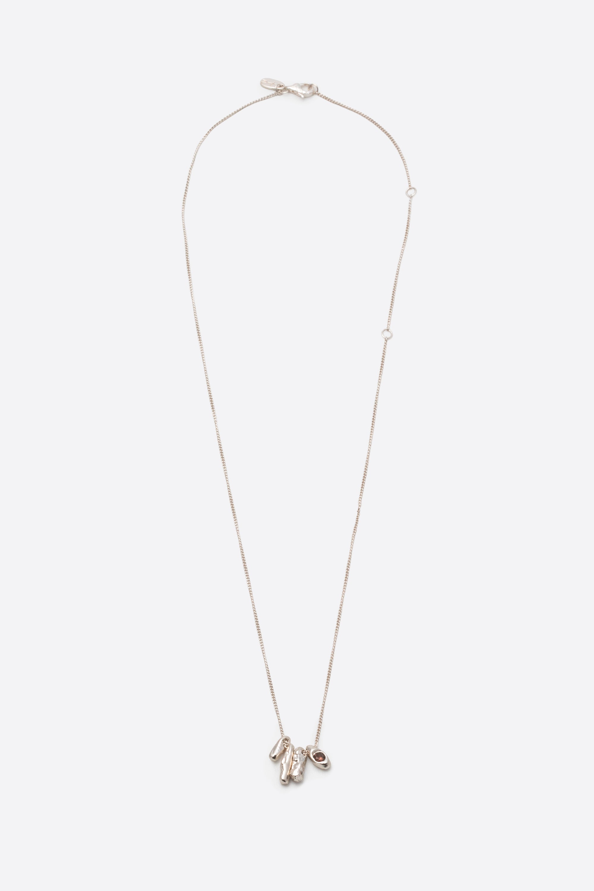 Sculptural silver pendant necklace with dark gemstone on fine chain