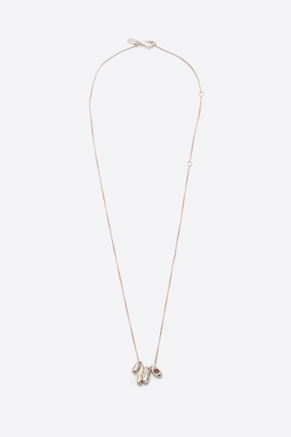 Sculptural silver pendant necklace with dark gemstone on fine chain