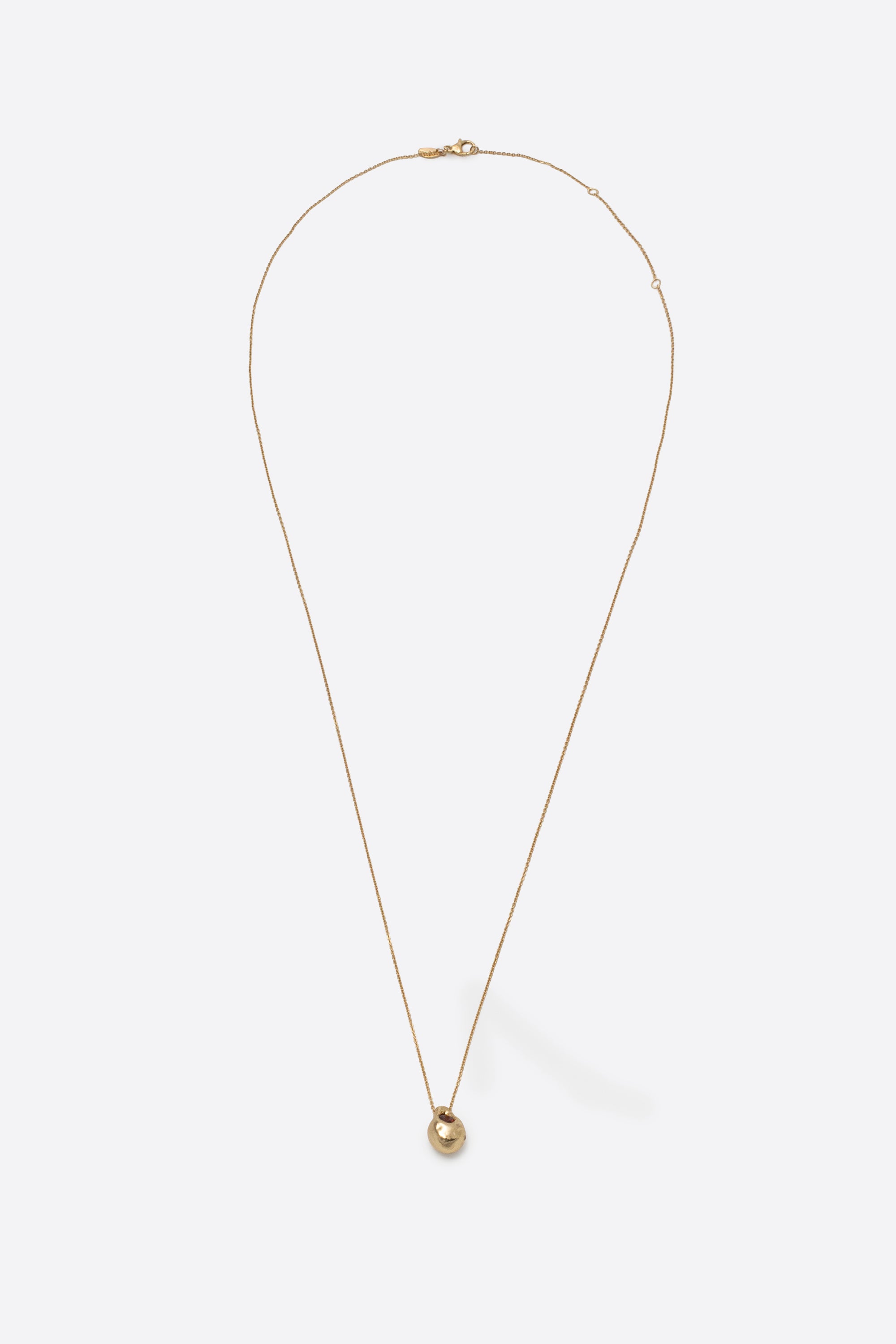 Long gold pendant necklace with sculptural gemstone charm on fine chain