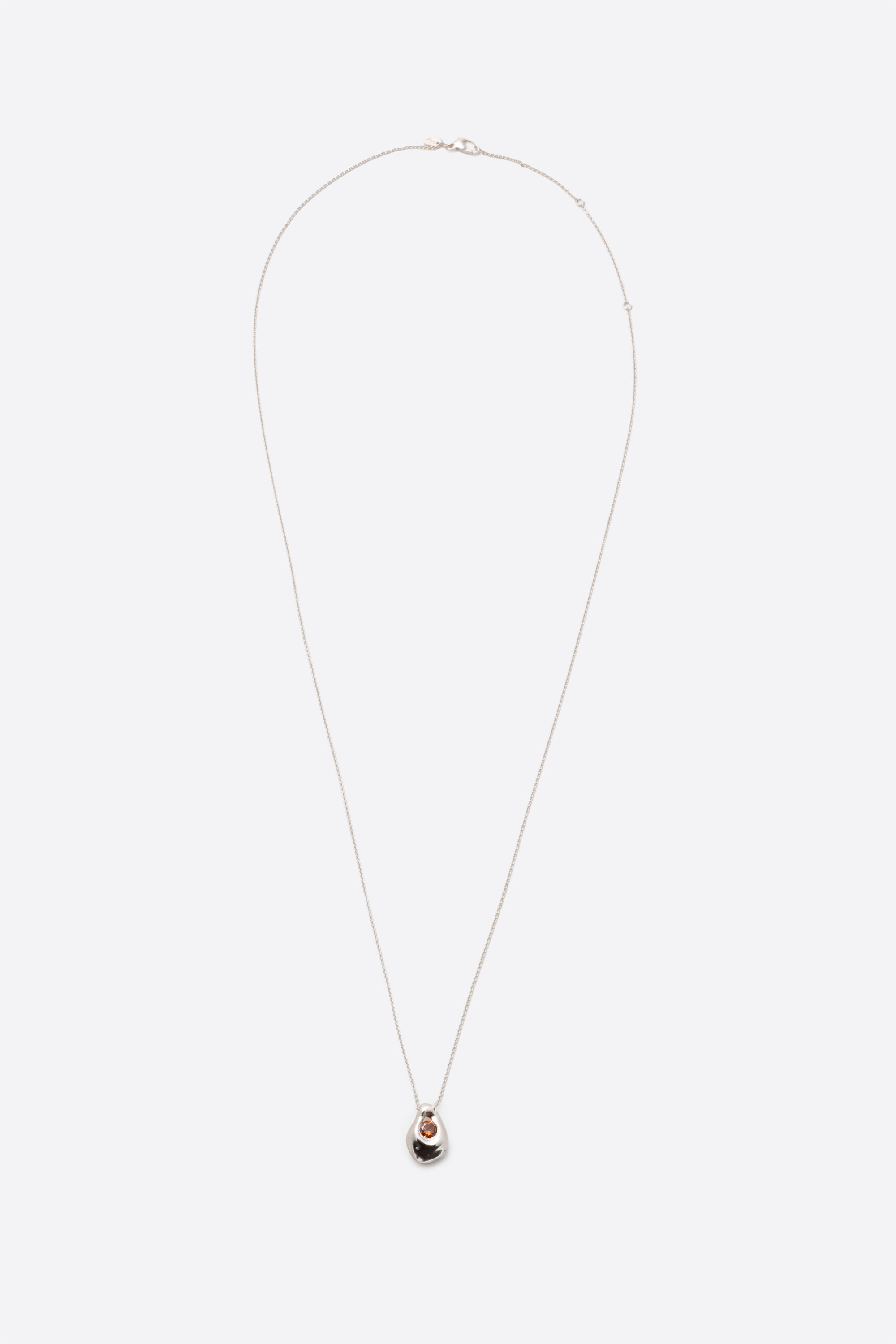 Long silver pendant necklace with sculptural gemstone charm on fine chain