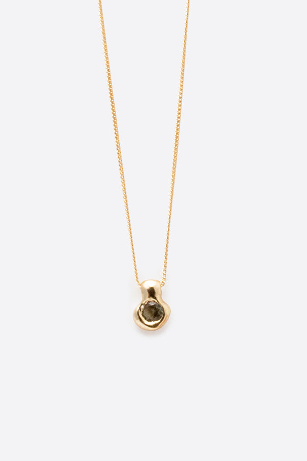 Sculptural gold pendant necklace with dark gemstone on fine chain