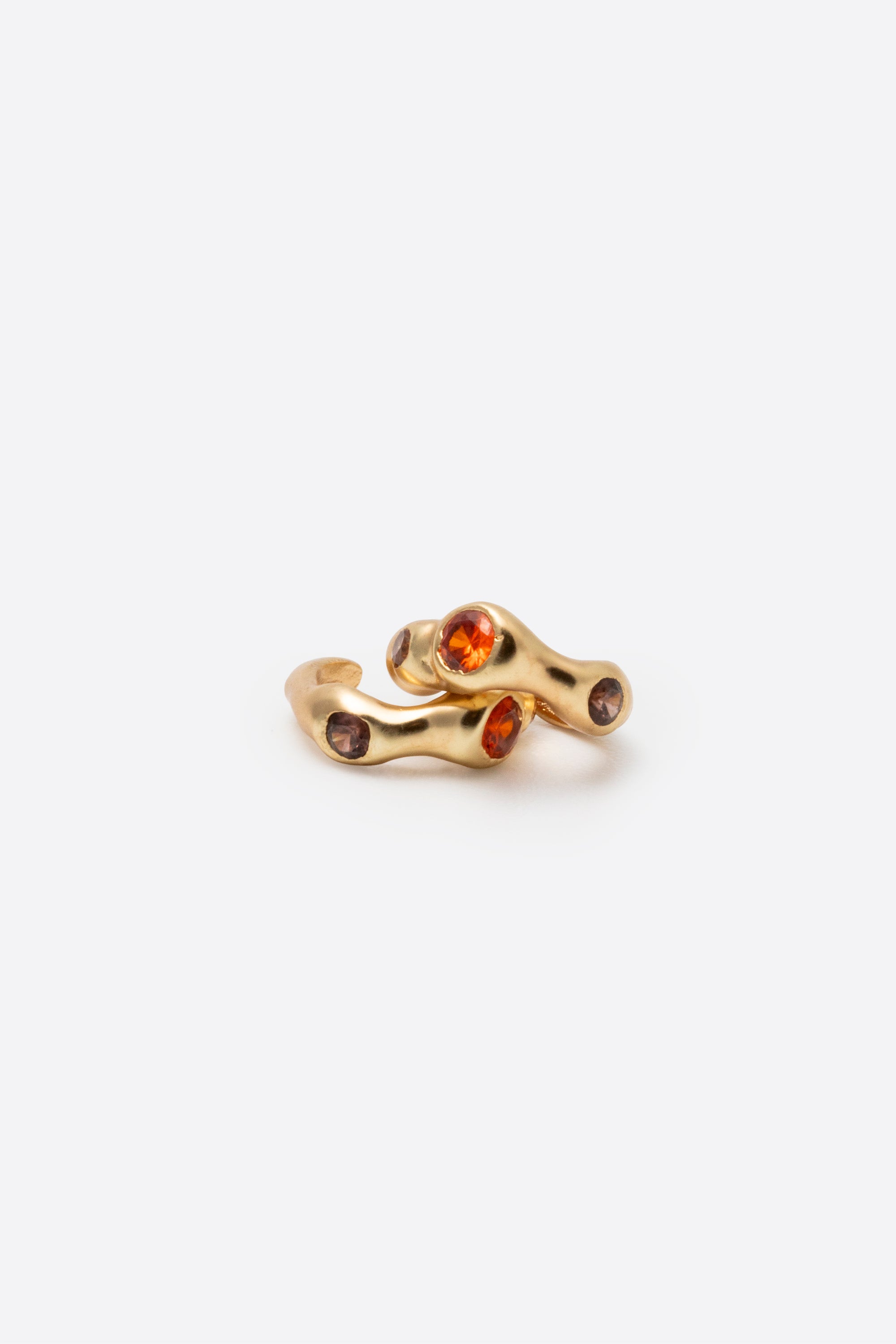 Side view of sculptural gold gemstone huggie earrings