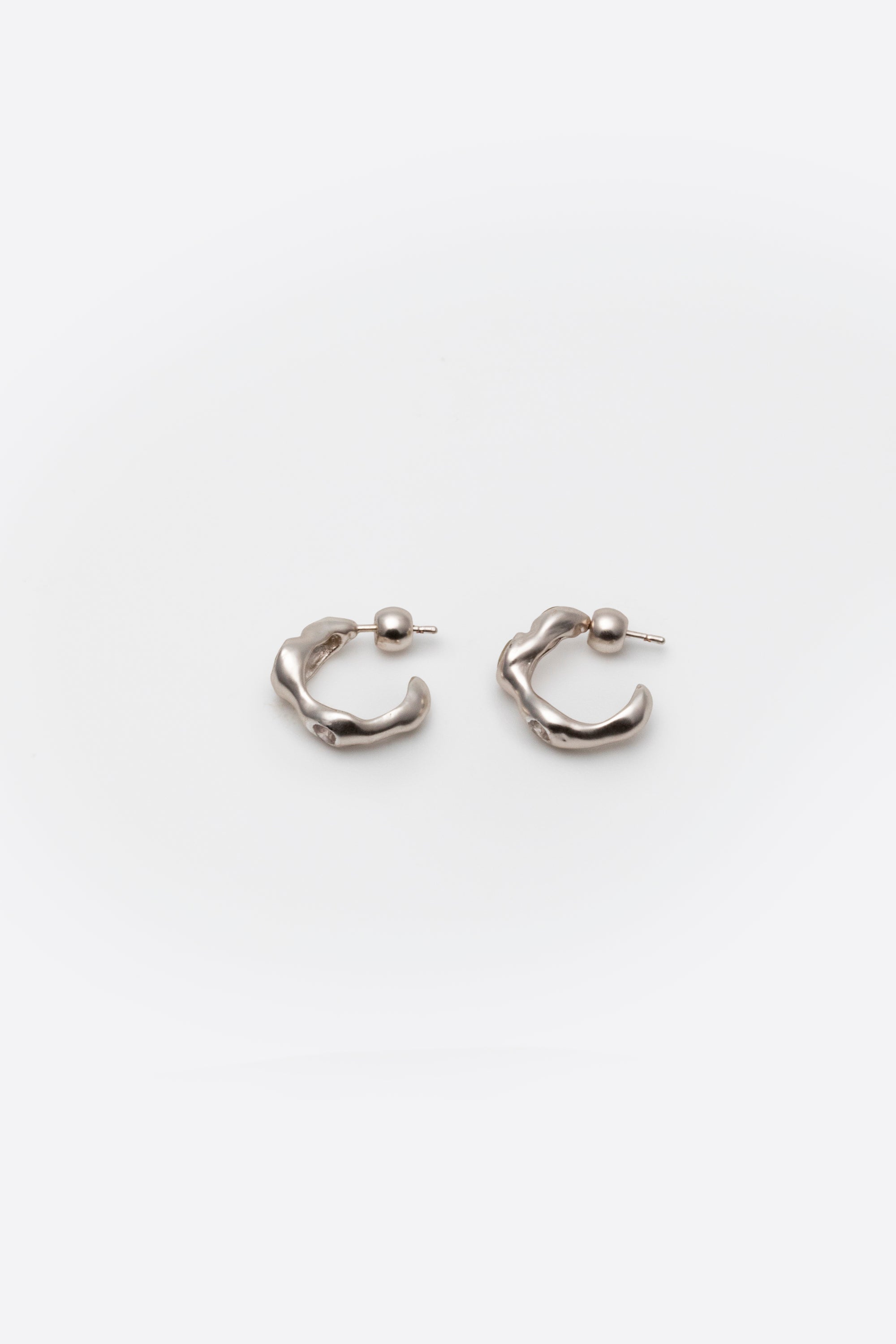 Side view of sculptural sterling silver gemstone huggie earrings