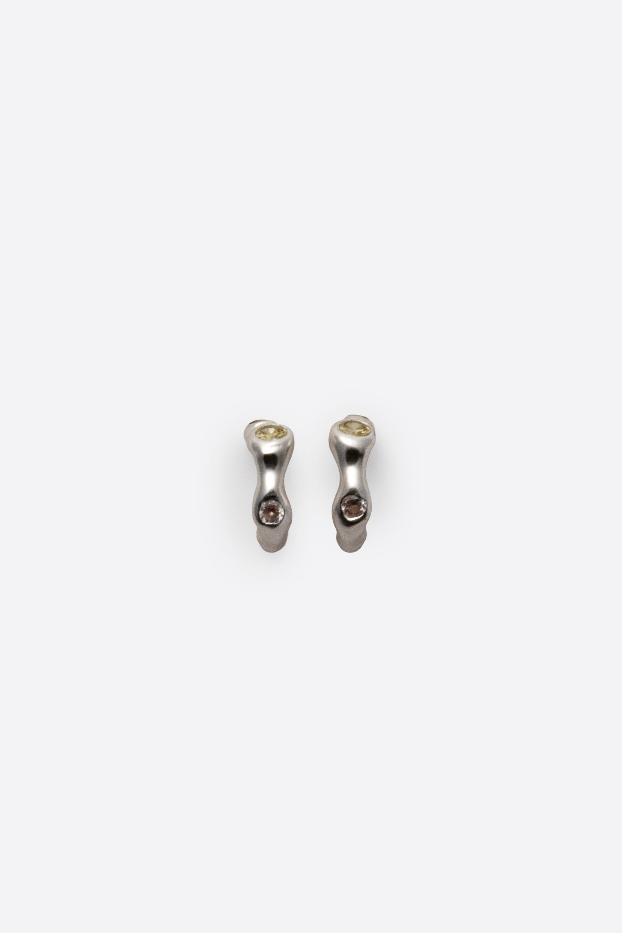 Sculptural sterling silver gemstone huggie earrings on white background