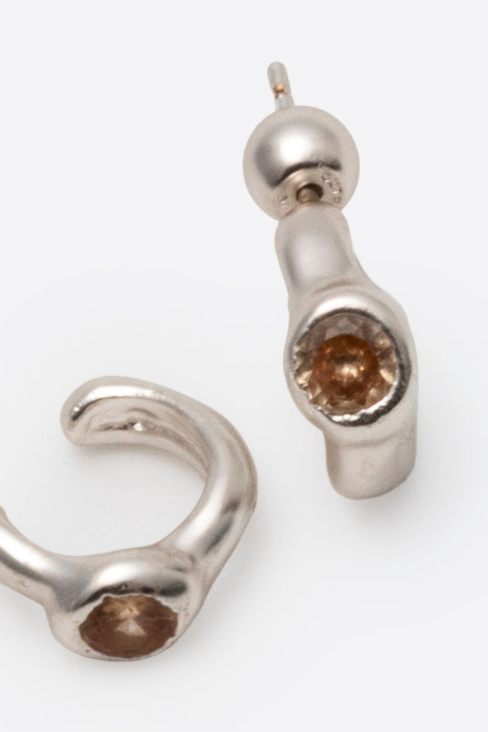 Close-up of sterling silver gemstone stud earrings with sculptural setting