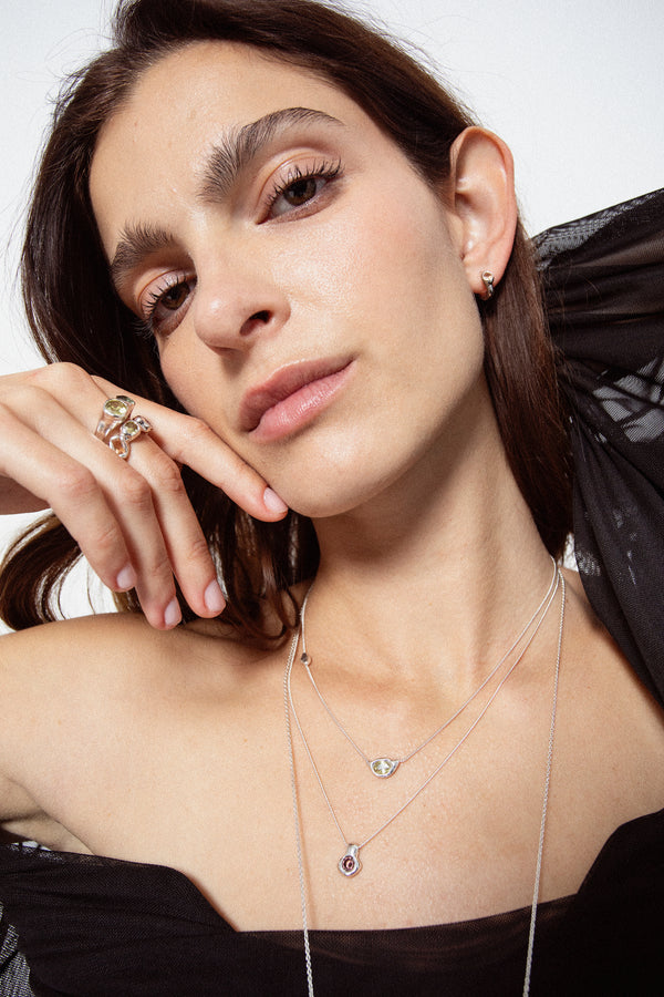 Model styling sculptural sterling silver gemstone stud earrings with matching jewelry