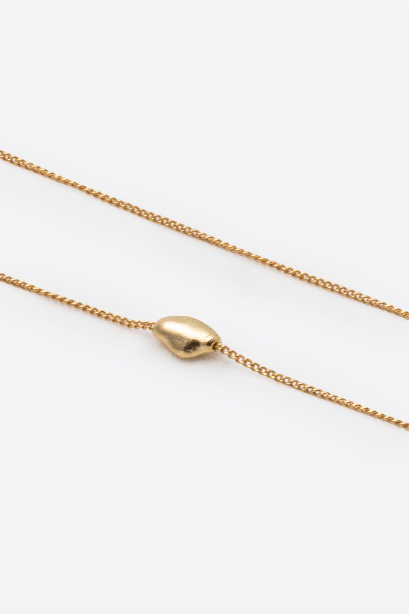 Gold pendant necklace showing chain and adjustable slider detail