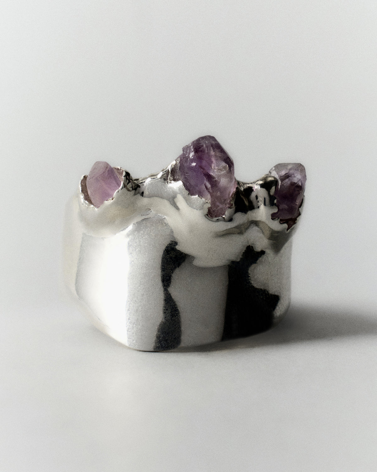 Amatista Ring in silver: wide polished ring with small purple stones set along the top.