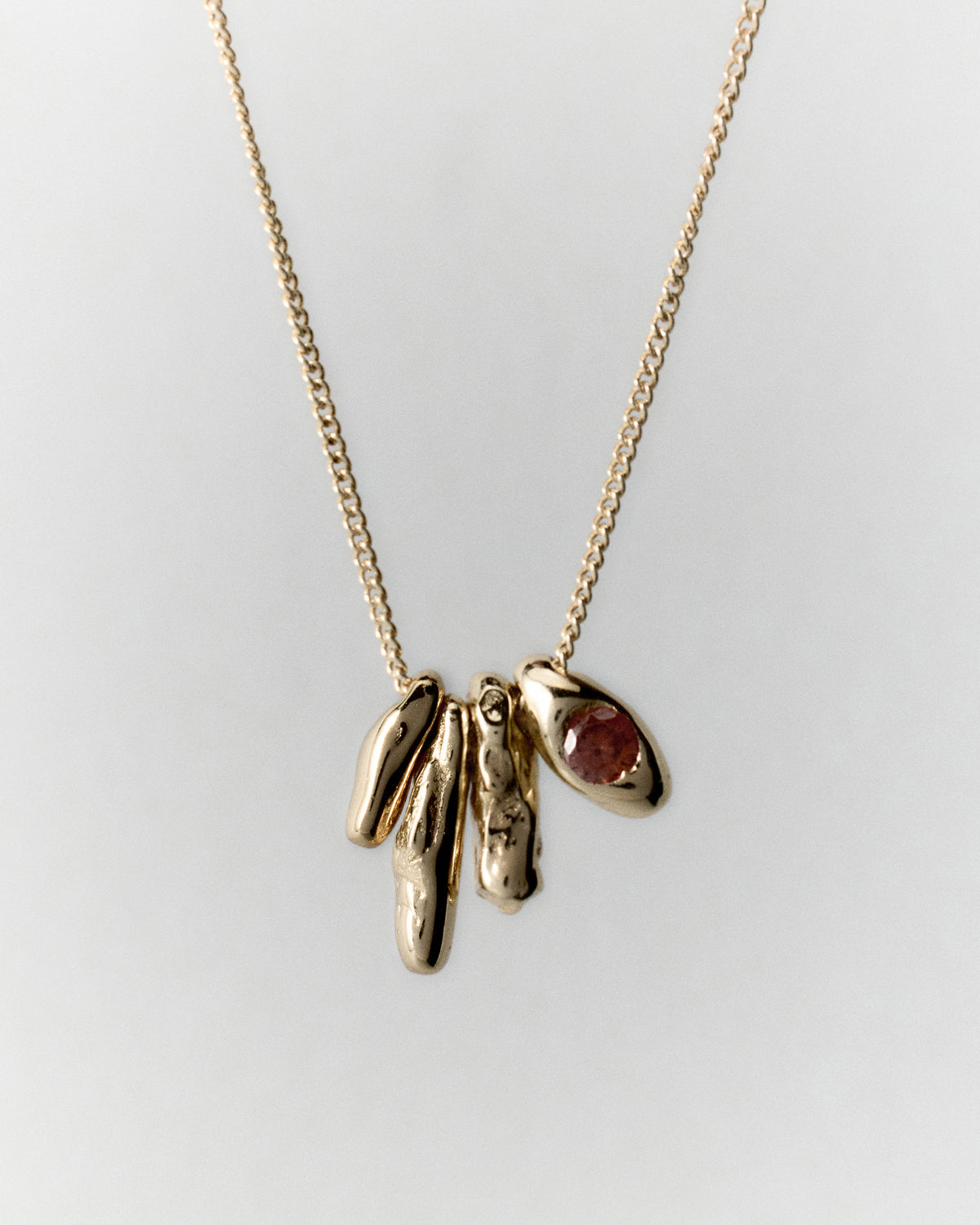 Dolomitas Necklace in gold: necklace with a cluster of irregular pendants and a red stone.