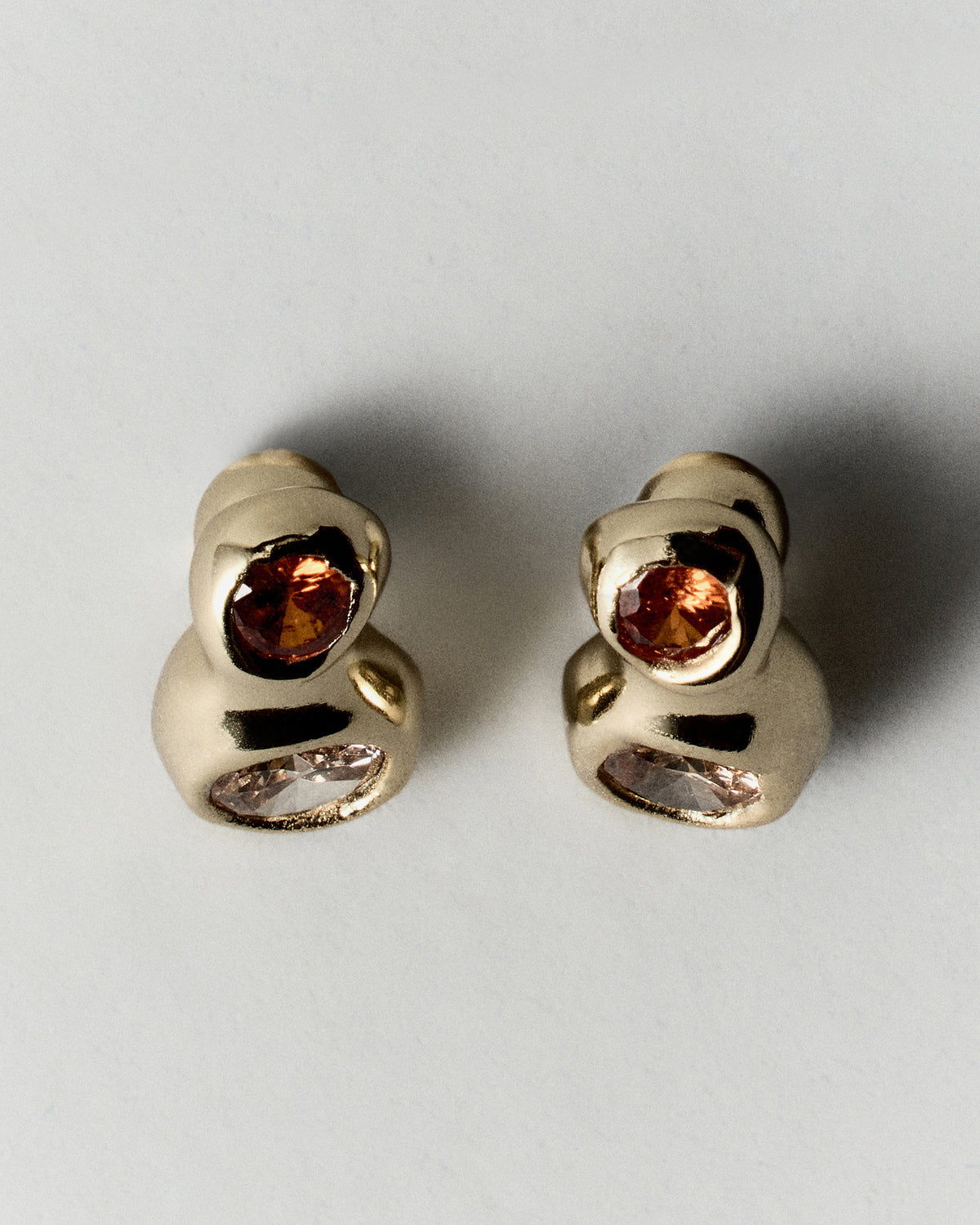 Double Pepita Studs Earrings in gold: side view showing the double-stone studs' sculptural curved settings.