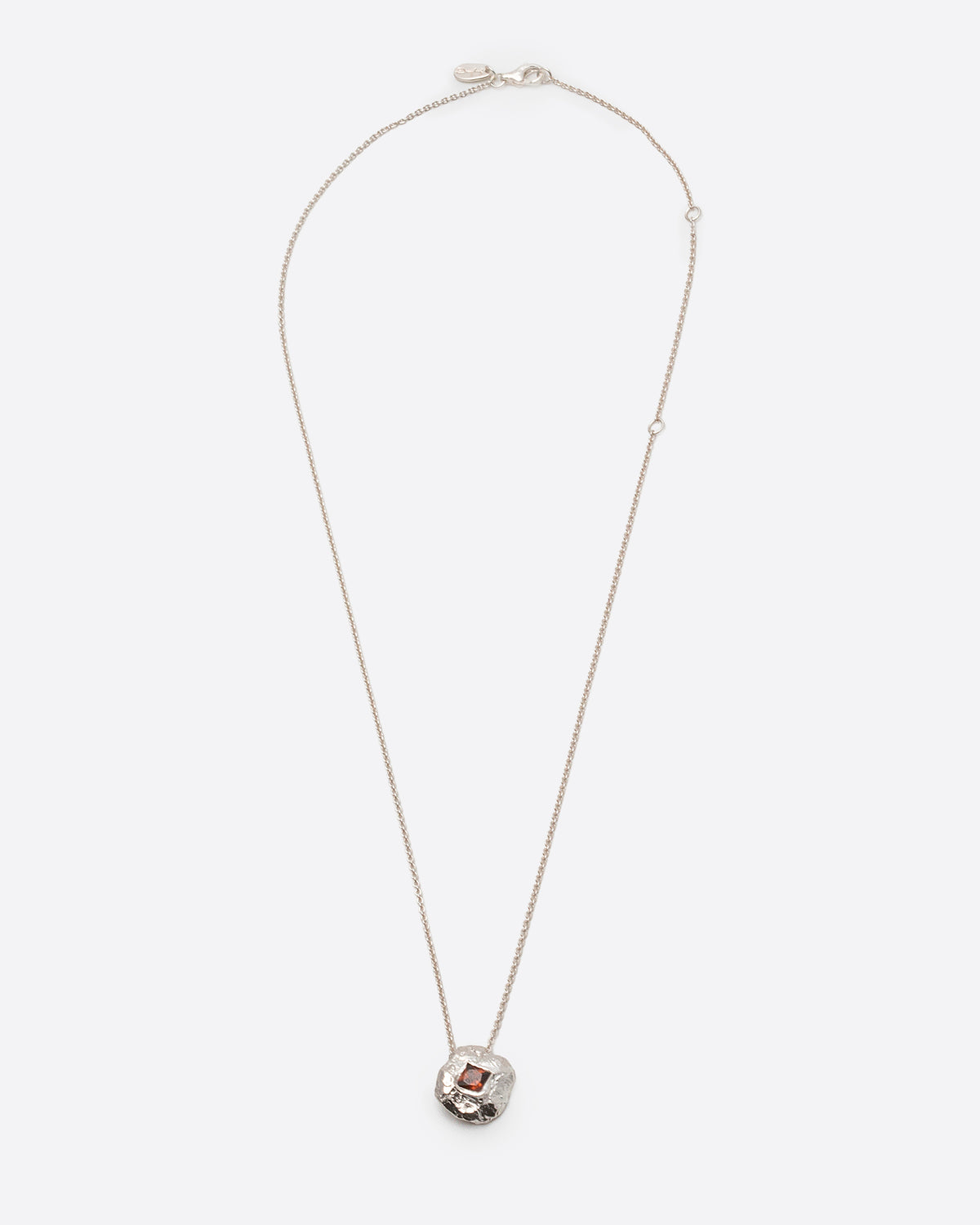 Helios Necklace in silver: full-length view of the fine chain and small round pendant.