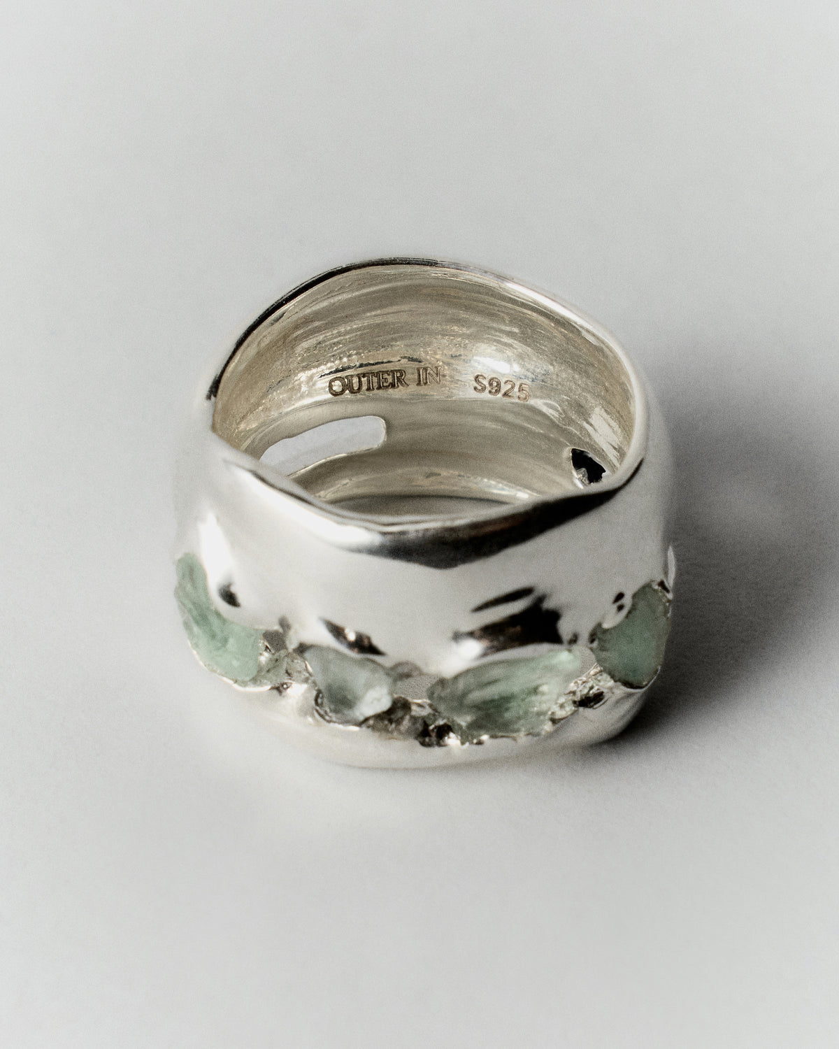 Inside Fluorita Ring in silver: angled view of the wide green-stone ring and interior engraving.
