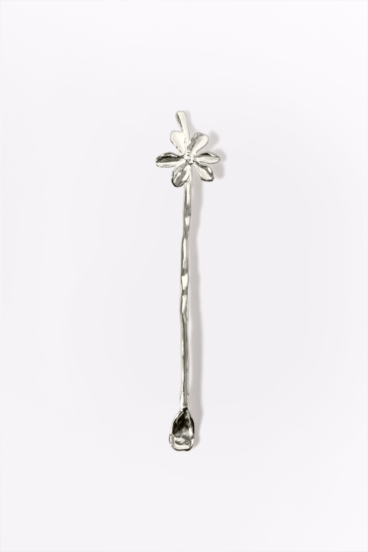 Silver strring stick with floral design on a white background