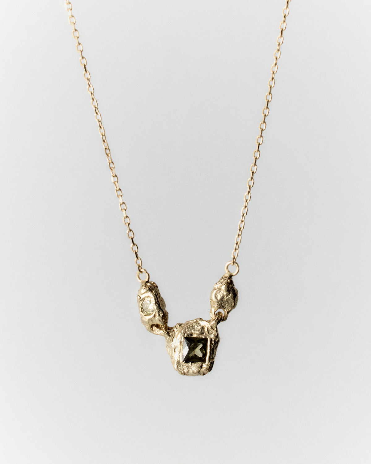 Juno Necklace in gold: necklace with small irregular links and inset stones at the center.