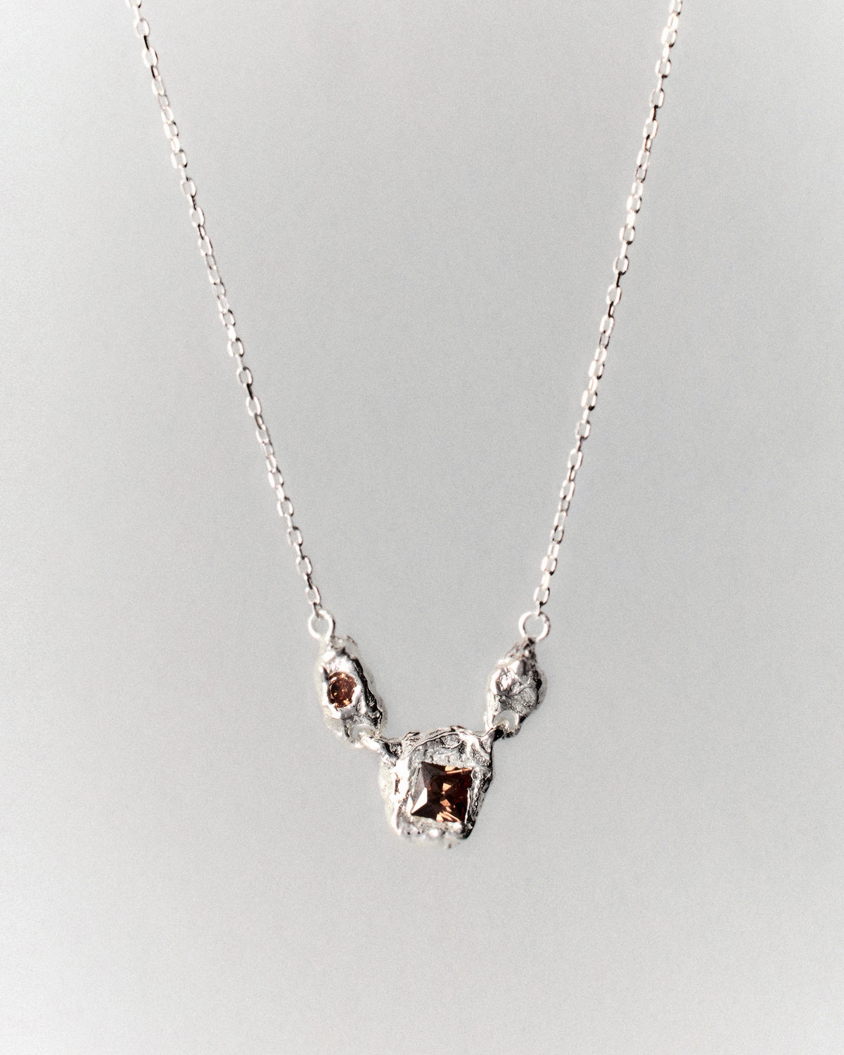 Juno Necklace in silver: necklace with small irregular links and inset stones at the center.
