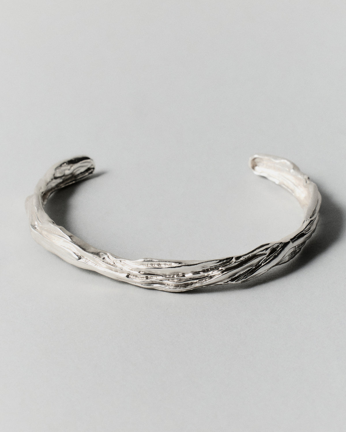Layered Earth Cuff in silver: open slender cuff with flowing textured surface.