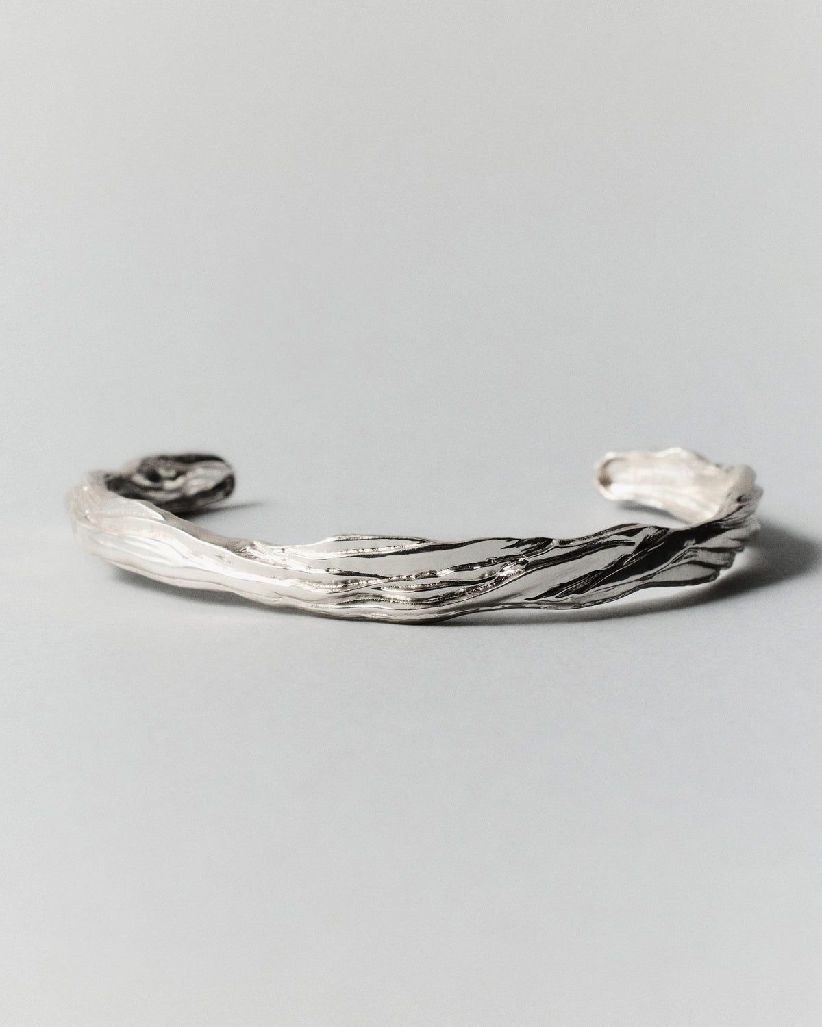 Layered Earth Cuff in silver: low angled view of the open cuff and its raised edges.