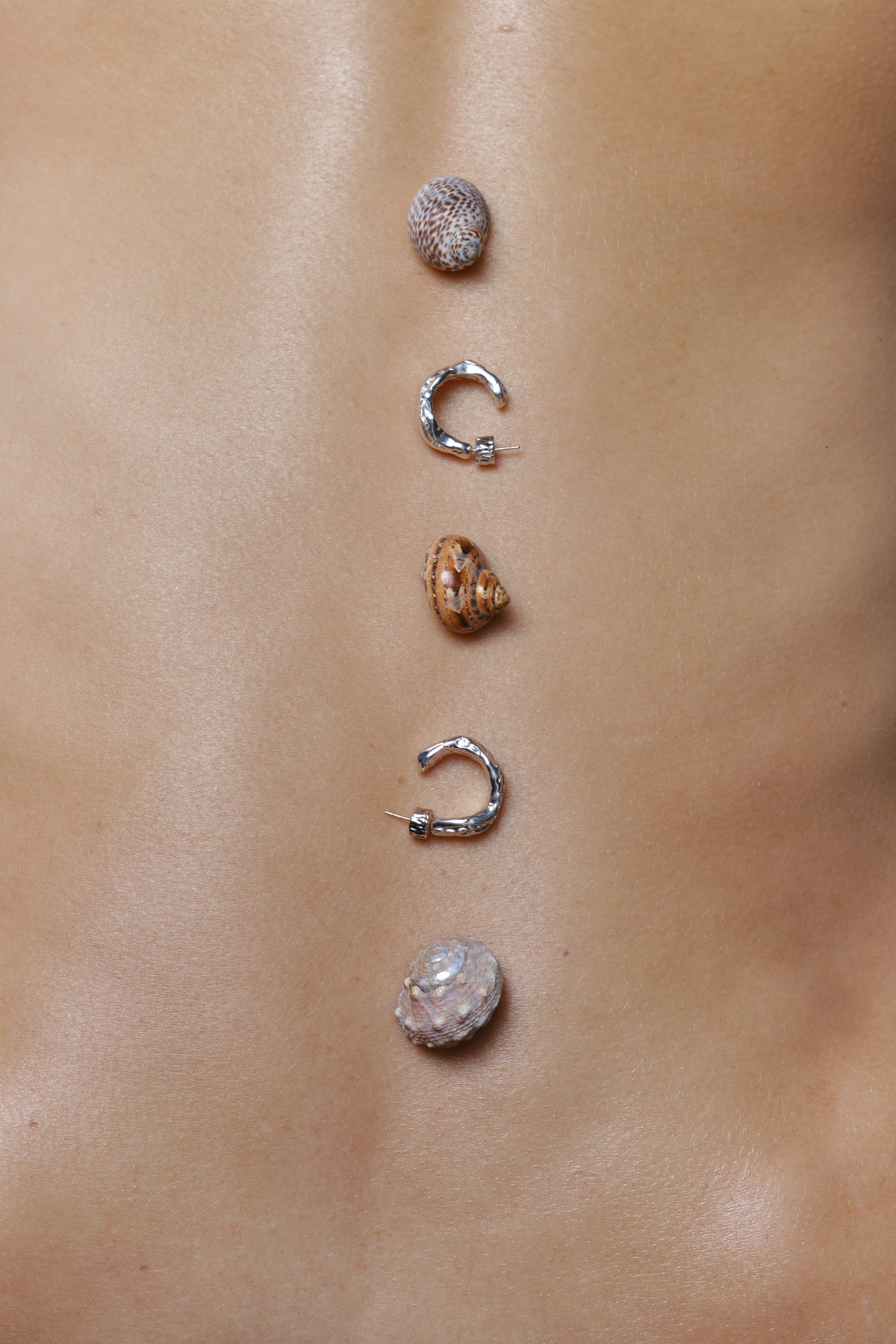 Layered Earth Hoop Earrings in silver: silver and gold hoop earrings styled with small stones.