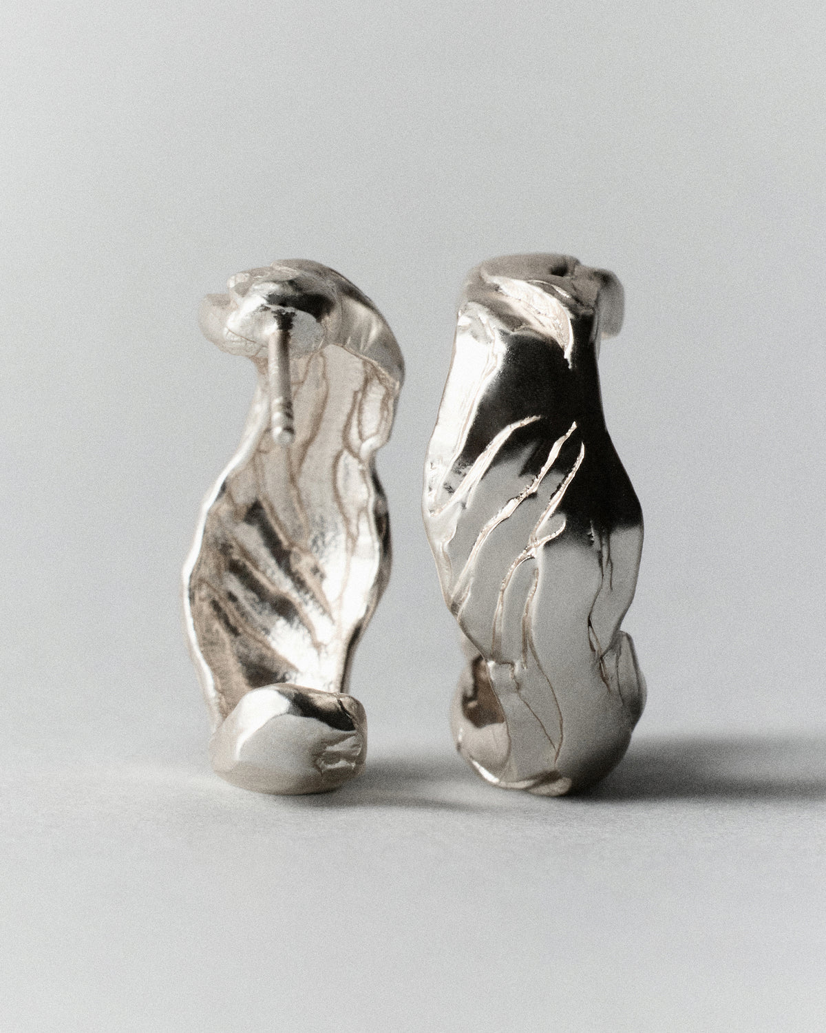 Layered Earth Hoops in silver: pair of textured hoops standing upright, front view.