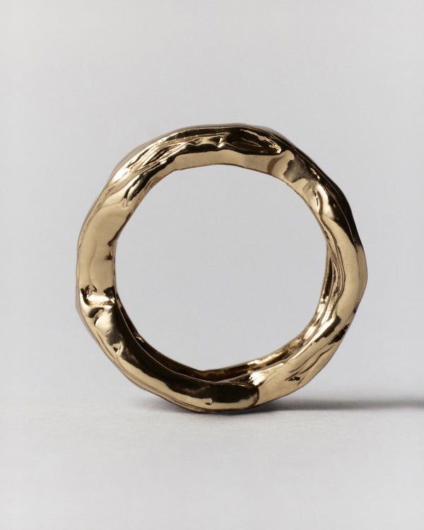 Layered Earth Ring in gold: ring standing upright showing its irregular textured circular band.
