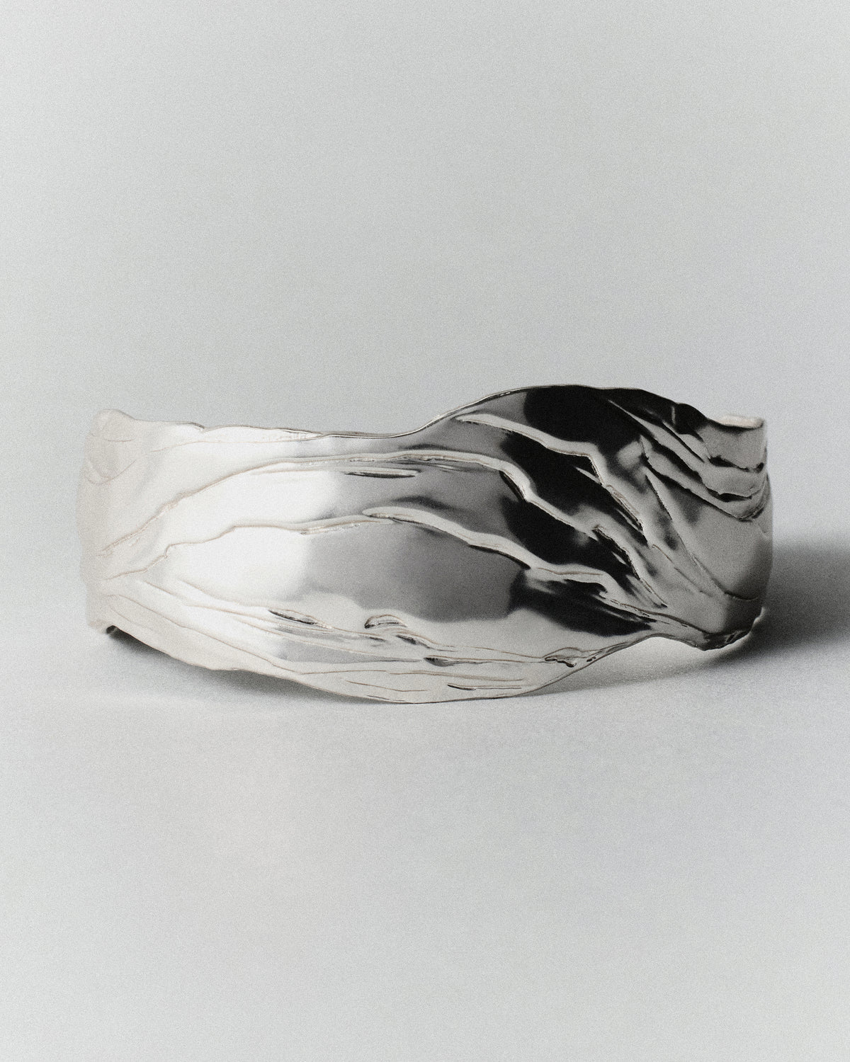 Layered Earth Statement Cuff in silver: wide cuff shown from the front with flowing engraved textures.