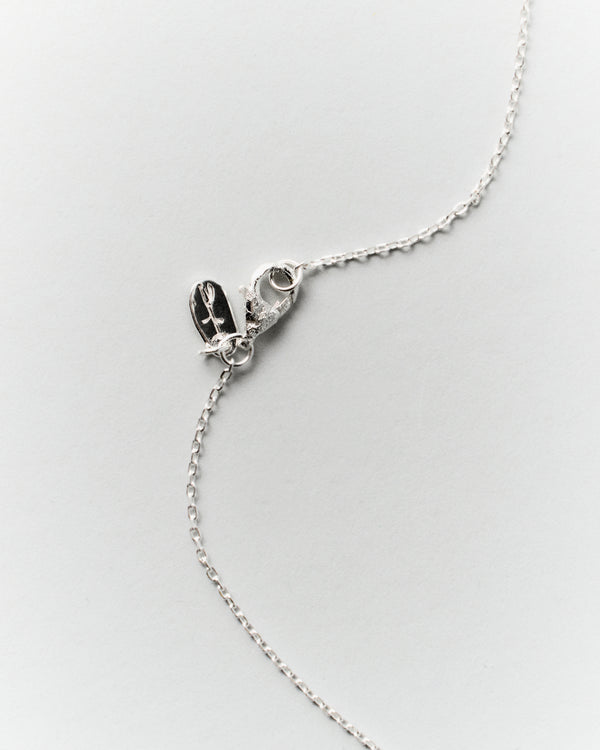 Nova Necklace in silver: close-up of the necklace clasp and oval brand tag.