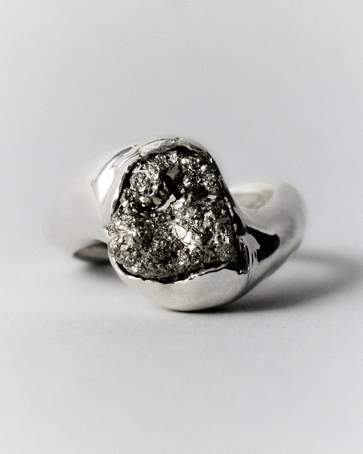 Pirita Ring in silver: ring with a rough dark metallic stone in a smooth setting.