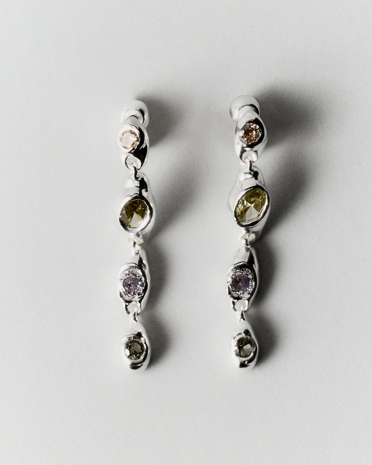 Prado Pepita Long Earrings in silver: pair of long dangling earrings with pale green and purple stones.