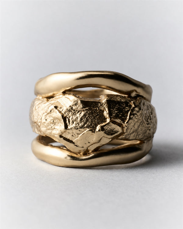 Rio Ring in gold: front view of the wide ring's rough center and smooth raised edges.