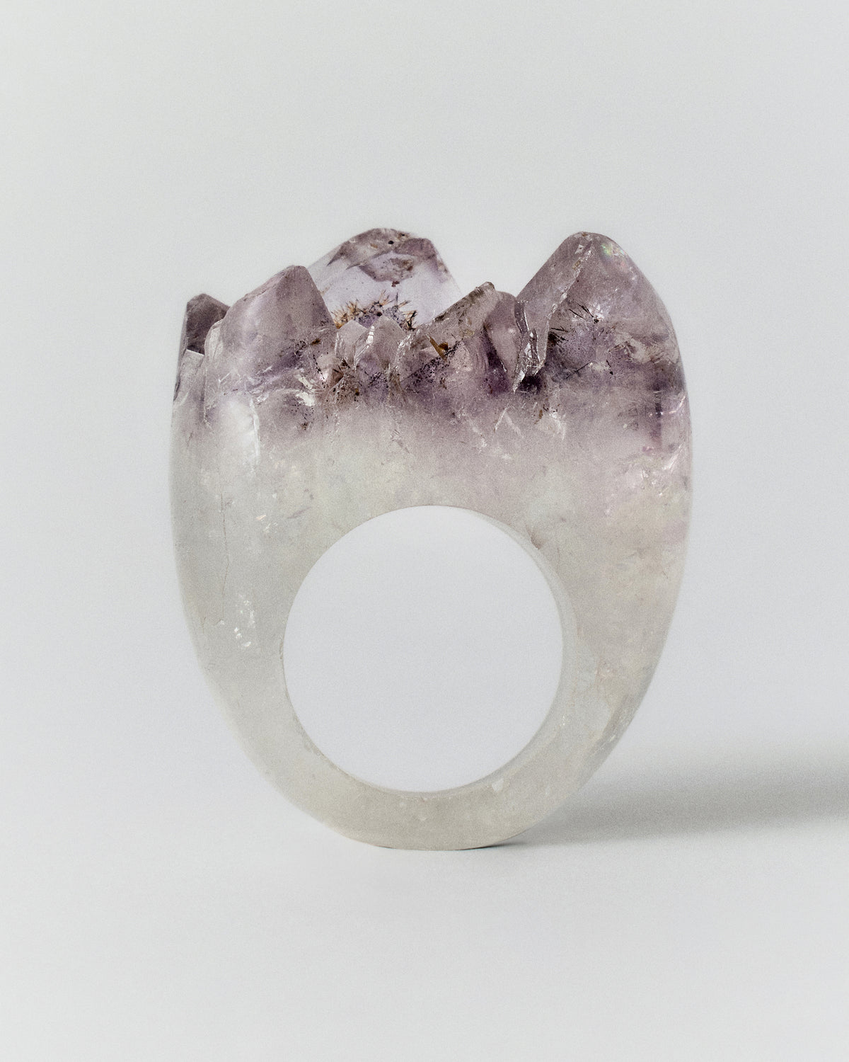 Roca Ring: translucent white ring topped with pointed purple crystals, front view.