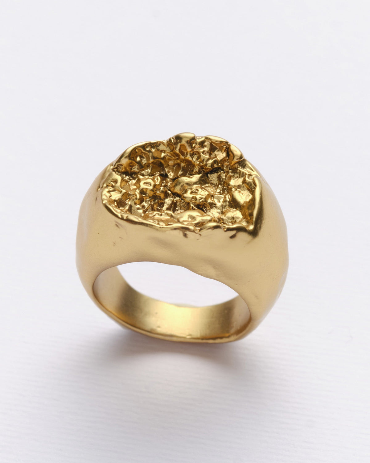 Rock Ring in gold: angled view of the ring's rough textured top.