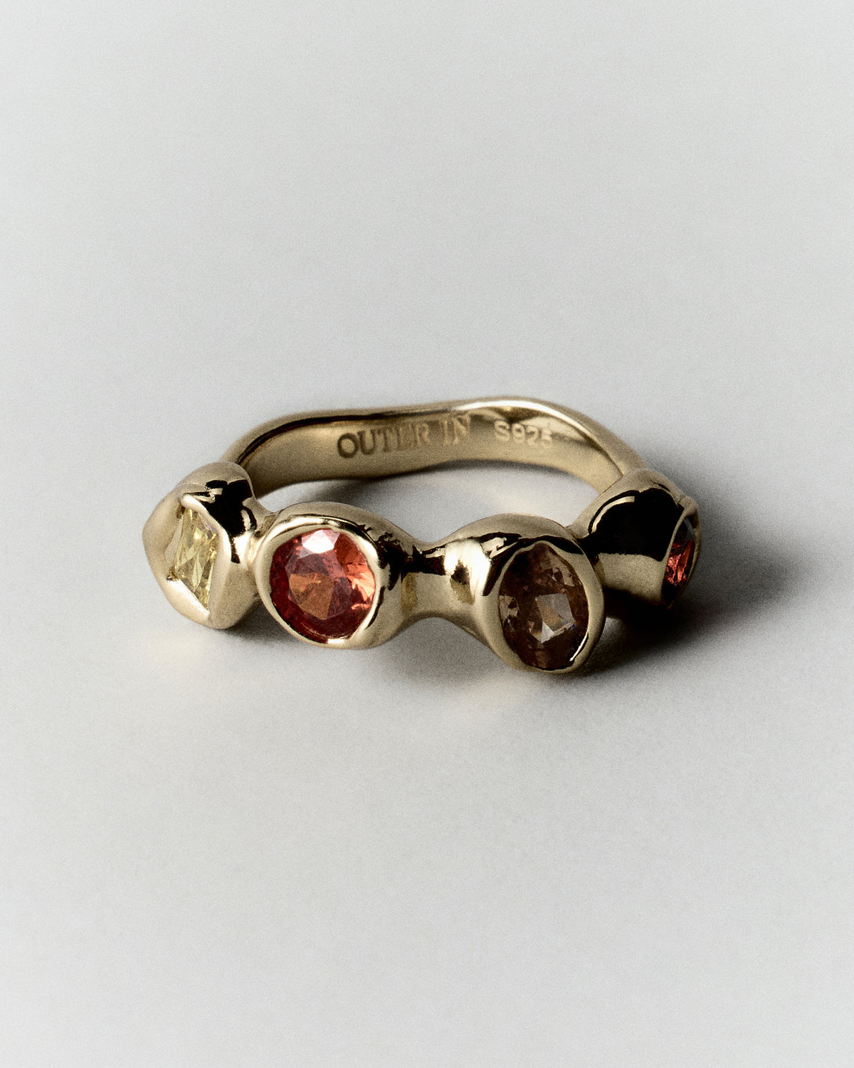 Sunset Pepita Ring in gold: angled view of a ring with three contrasting warm-colored stones.