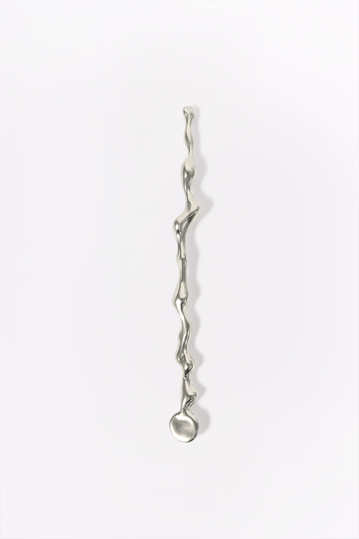 Sway Cutlery Stirring Stick in silver: full view of the sculptural stirring stick on white.