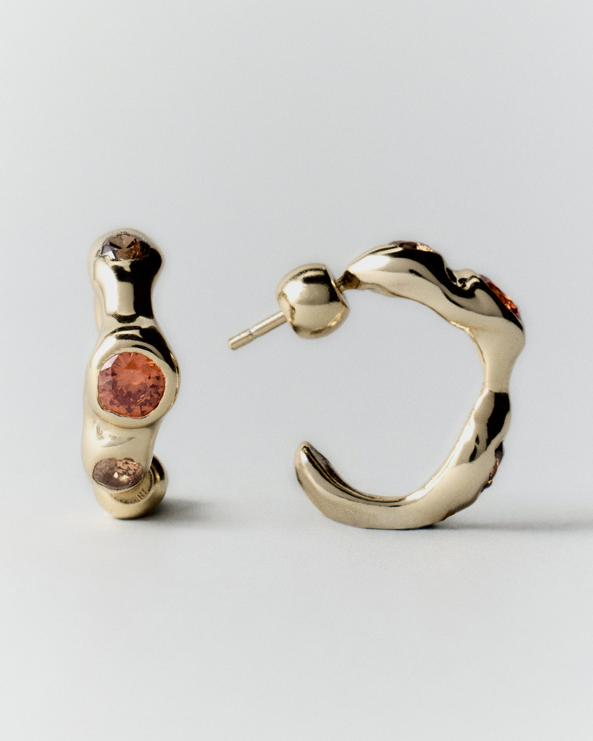 Tonka Hoops in gold: front and side views of a pair of hoops with warm-colored stones.