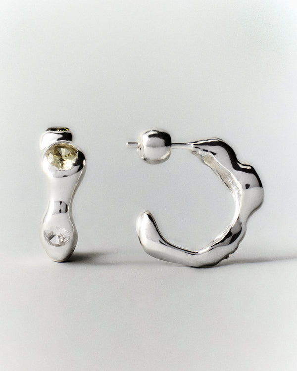 Tonka Hoops in silver: front and side views of a pair of hoops with pale green stones.