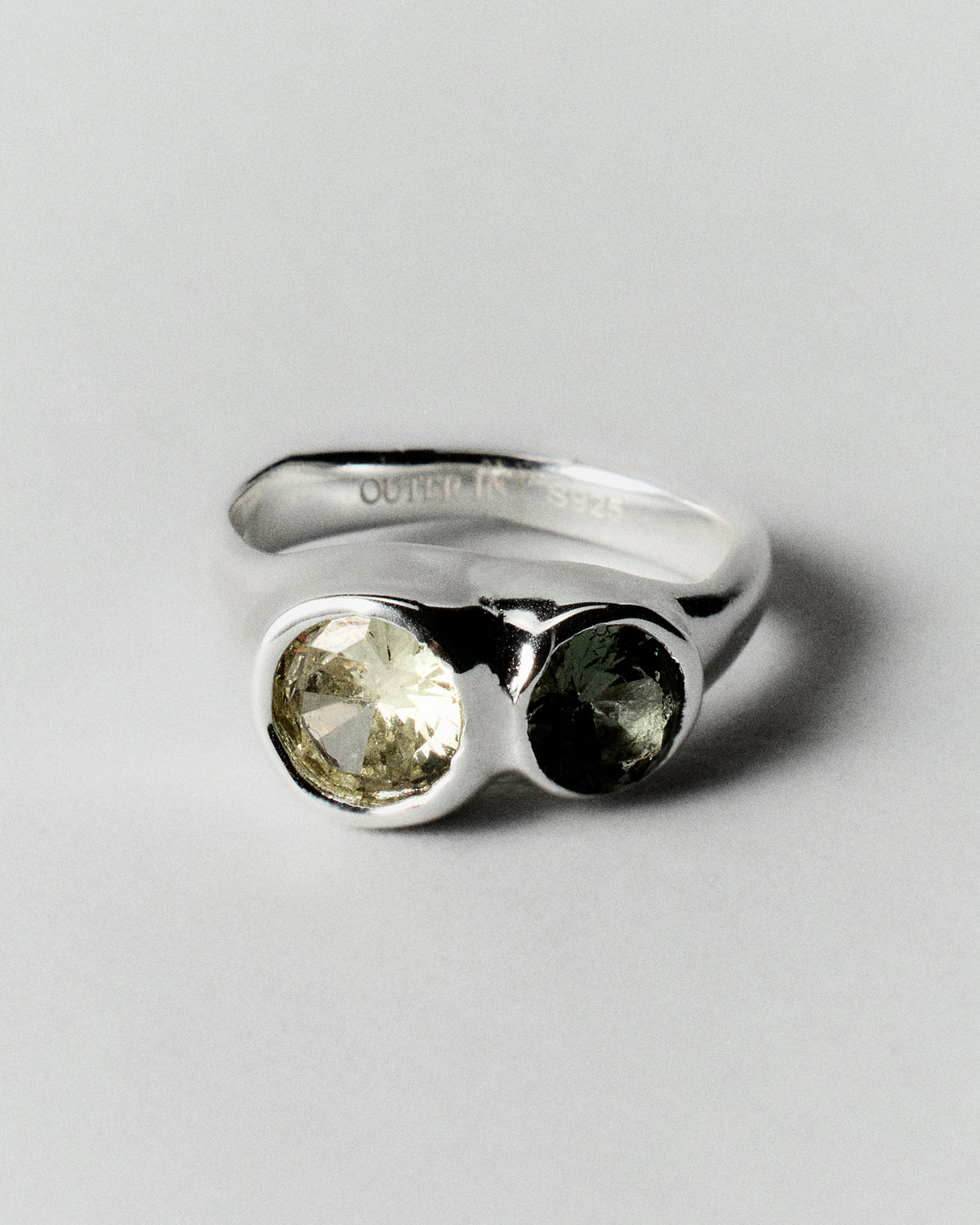 Tonka Ring in silver: angled view of the ring's paired green stone settings.