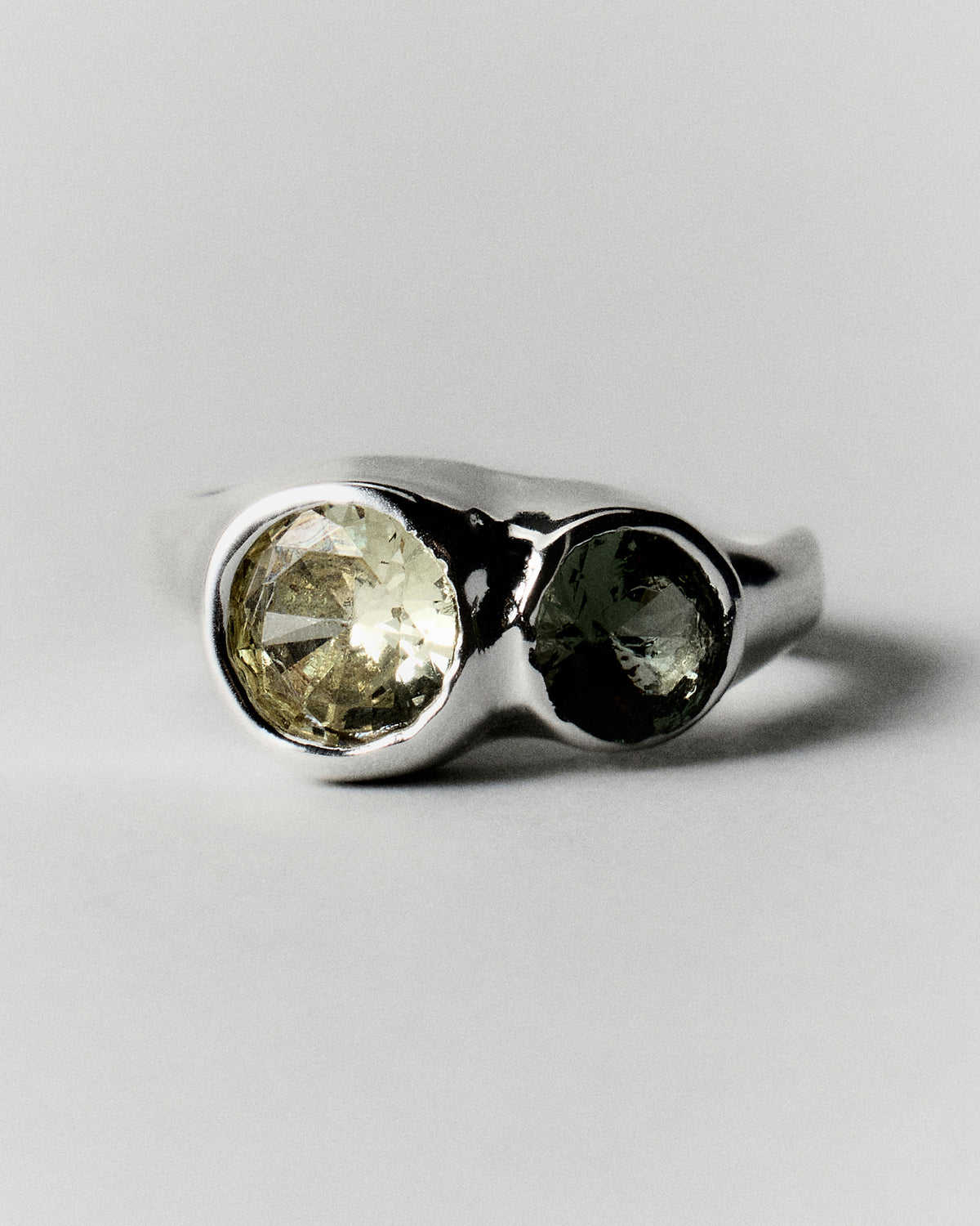 Tonka Ring in silver: front view of two contrasting green stones in smooth settings.