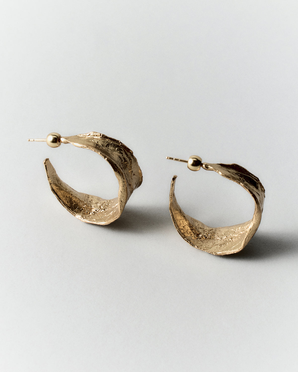 Vitalis II Hoops in gold: angled view showing the hoops' wide textured surfaces.