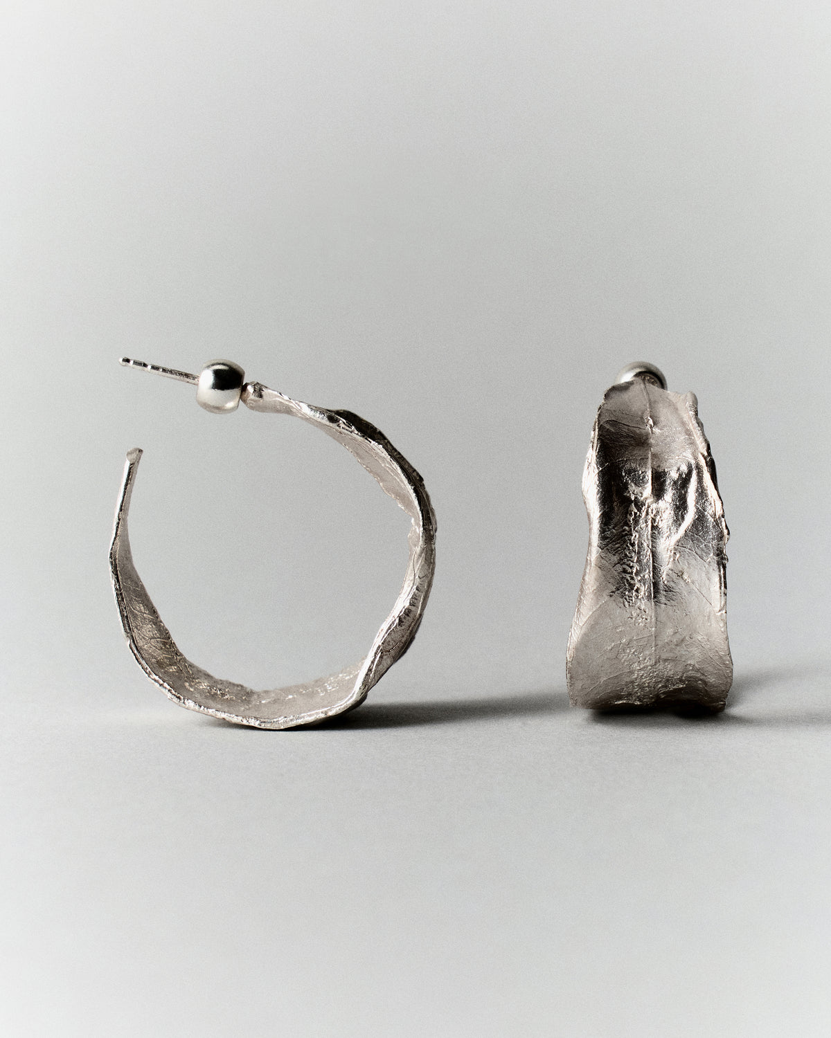 Vitalis II Hoops in silver: front and side profiles of the broad textured hoop earrings.