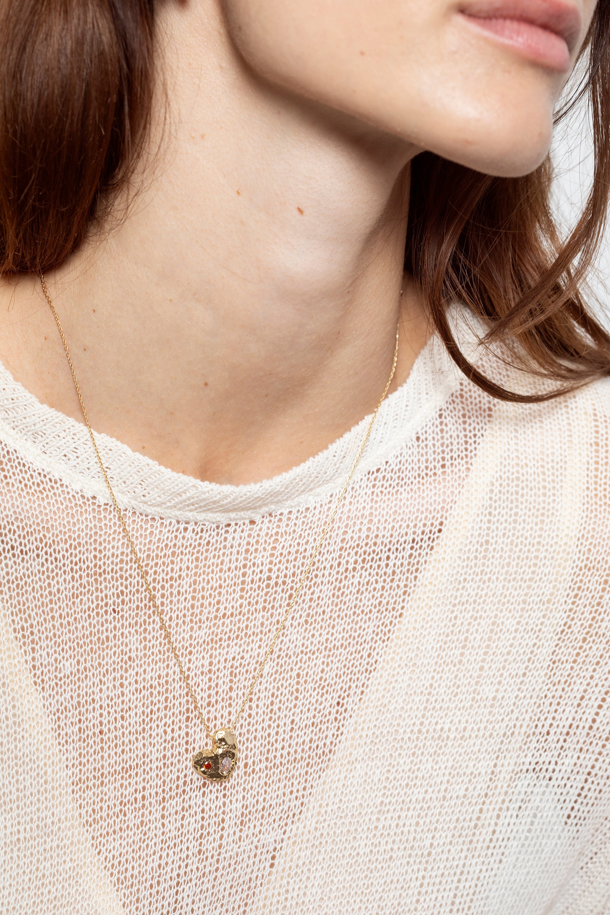 Gold solid heart pendant necklace with two stones worn on model